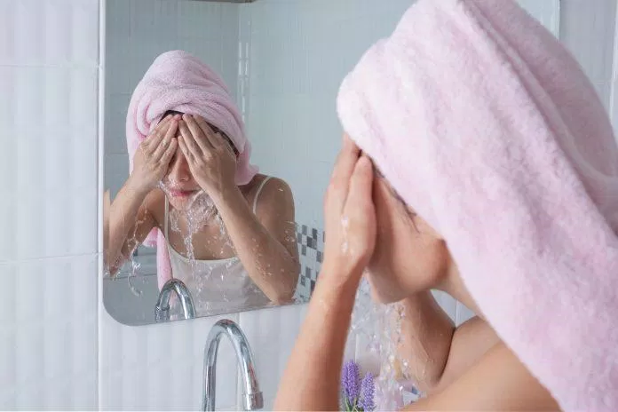 Asian girl washes face.